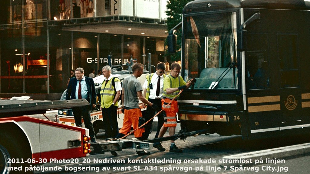 2011-06-30 Photo20_20 Nedriven kontaktledning orsakade strömlöst på linjen med påföljande bogsering av svart SL A34 spårvagn på linje 7 Spårväg City - Textad.jpg